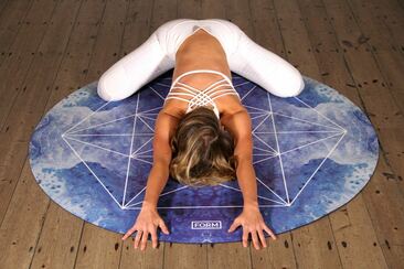 Woman stretching forward on a yoga mat.